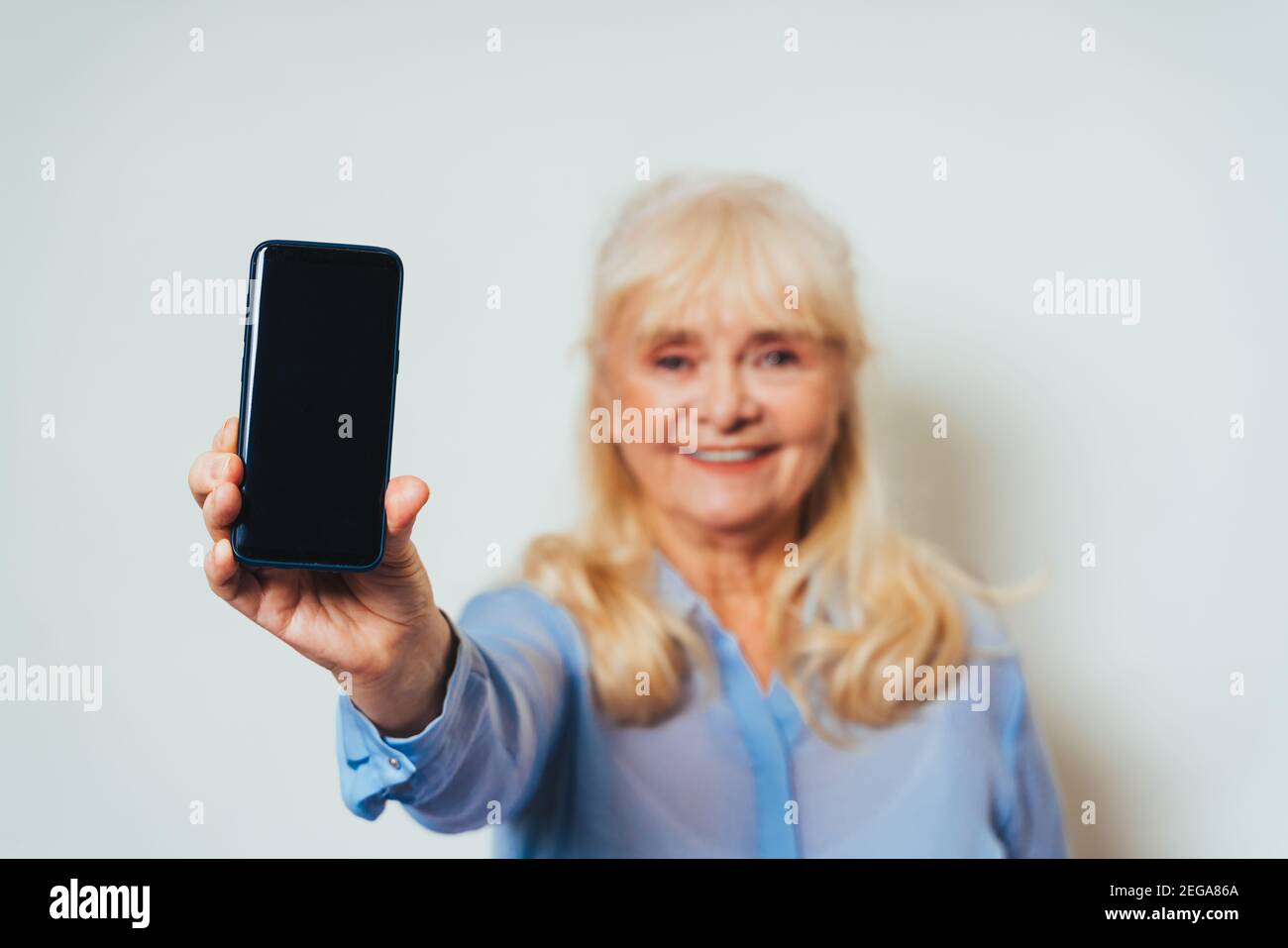 Belle femme âgée à la maison et regardant l'appareil photo sourire - joli adulte de plus de 60 ans, Banque D'Images