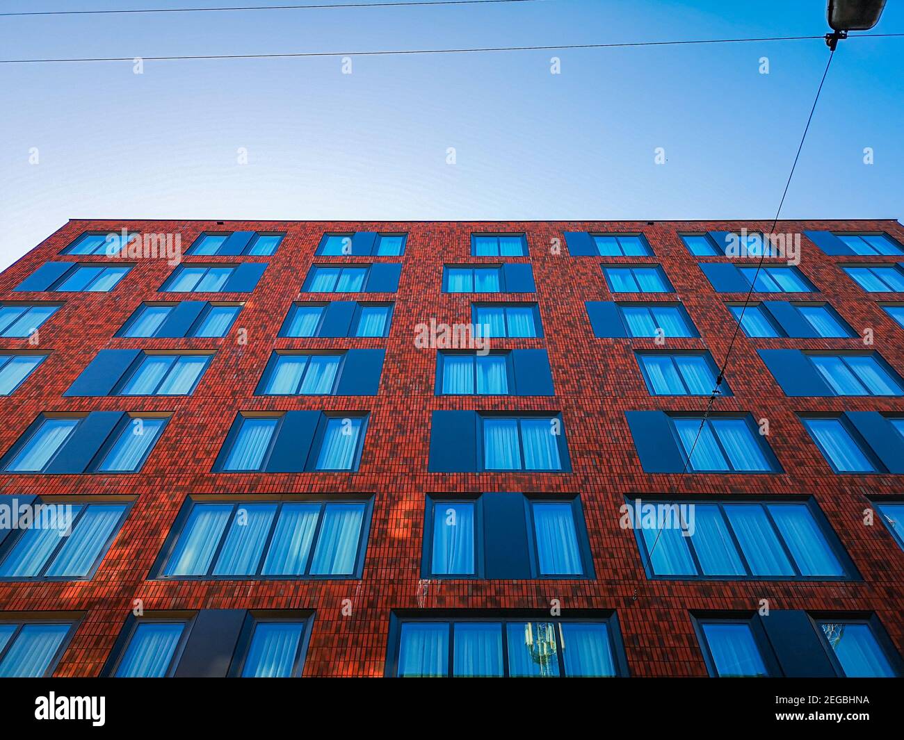 Wroclaw août 6 2019 vue vers le haut de la façade du bâtiment avec briques rouges et rideaux bleus dans les fenêtres Banque D'Images