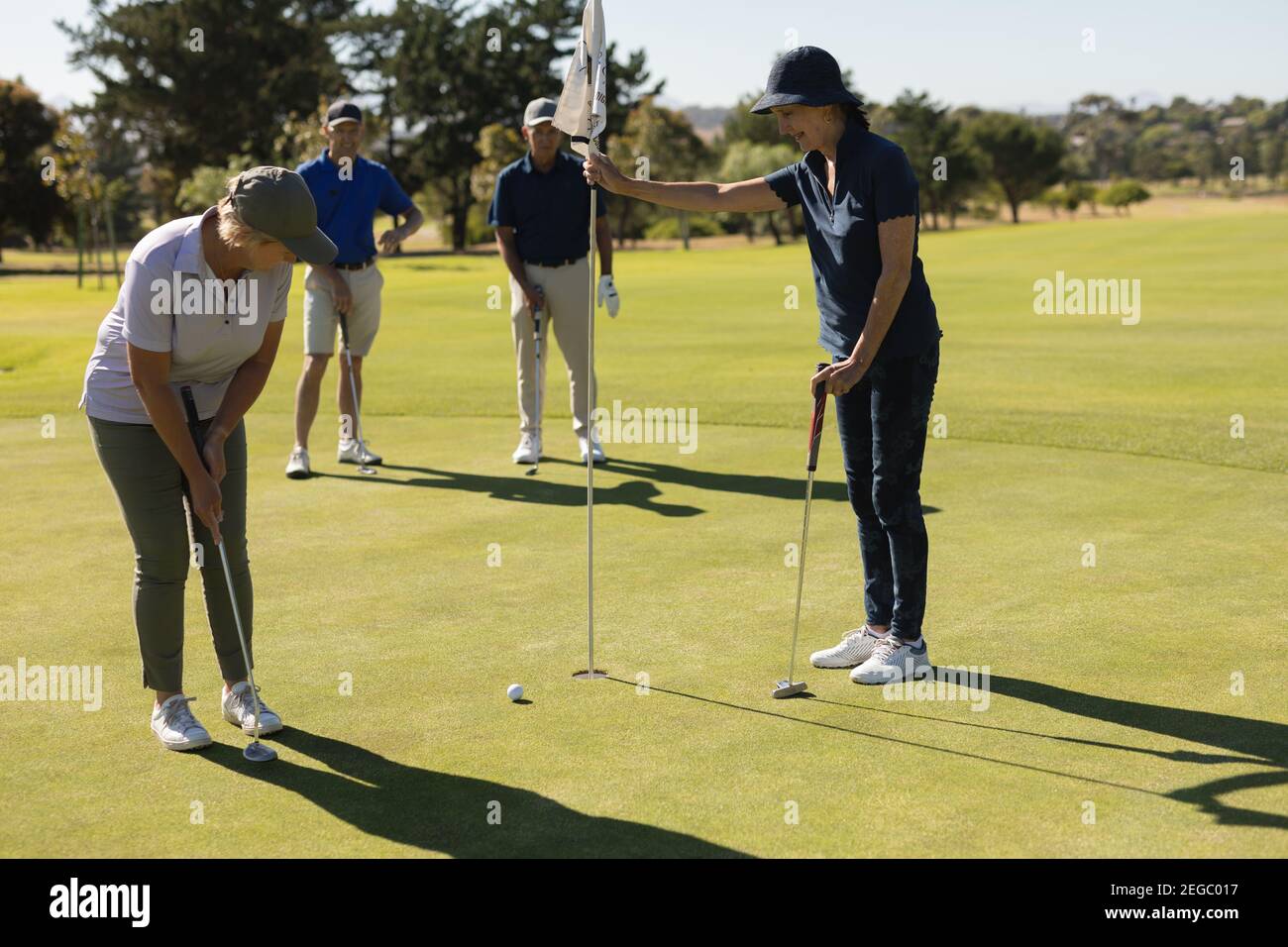 Trois hommes et femmes âgés de race blanche qui regardent la femme prise de vue sur le vert Banque D'Images