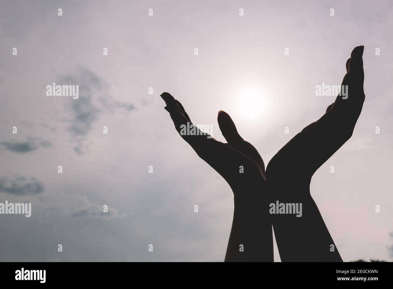 Mains levées atteignant le ciel. Concept de spiritualité, de bien-être, d'énergie positive Banque D'Images