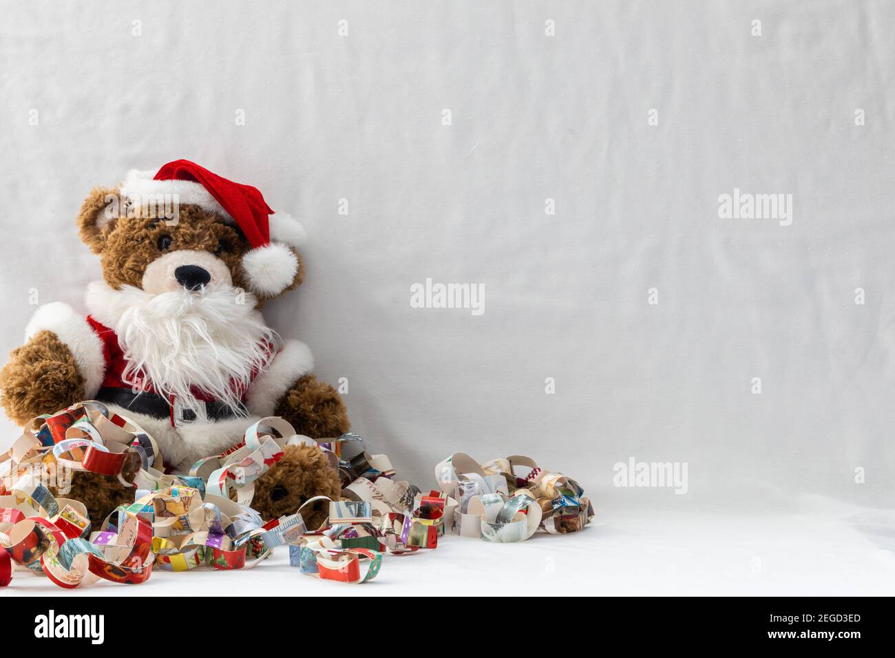 Ours en peluche de Noël dans une tenue de père Noël emmêlée d'un  arrière-plan blanc de la chaîne de papier avec espace de copie Photo Stock  - Alamy