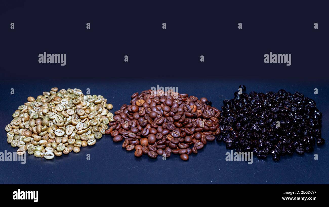 Grains de café non torréfiés, de type torréfacto naturel rôti et rôti de la variété Robusta sur fond noir. Café vert non torréfié sur la gauche Banque D'Images