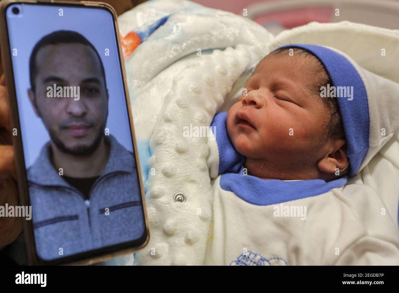 Khan Yunis Territoires Palestiniens 18 Fevrier 21 Une Photo Du Prisonnier Palestinien Muhammad Al Qudra Est Affichee Sur Un Telephone Portable A Cote De Son Nouveau Ne Bebe Garcon Qui A Ete Concu Avec