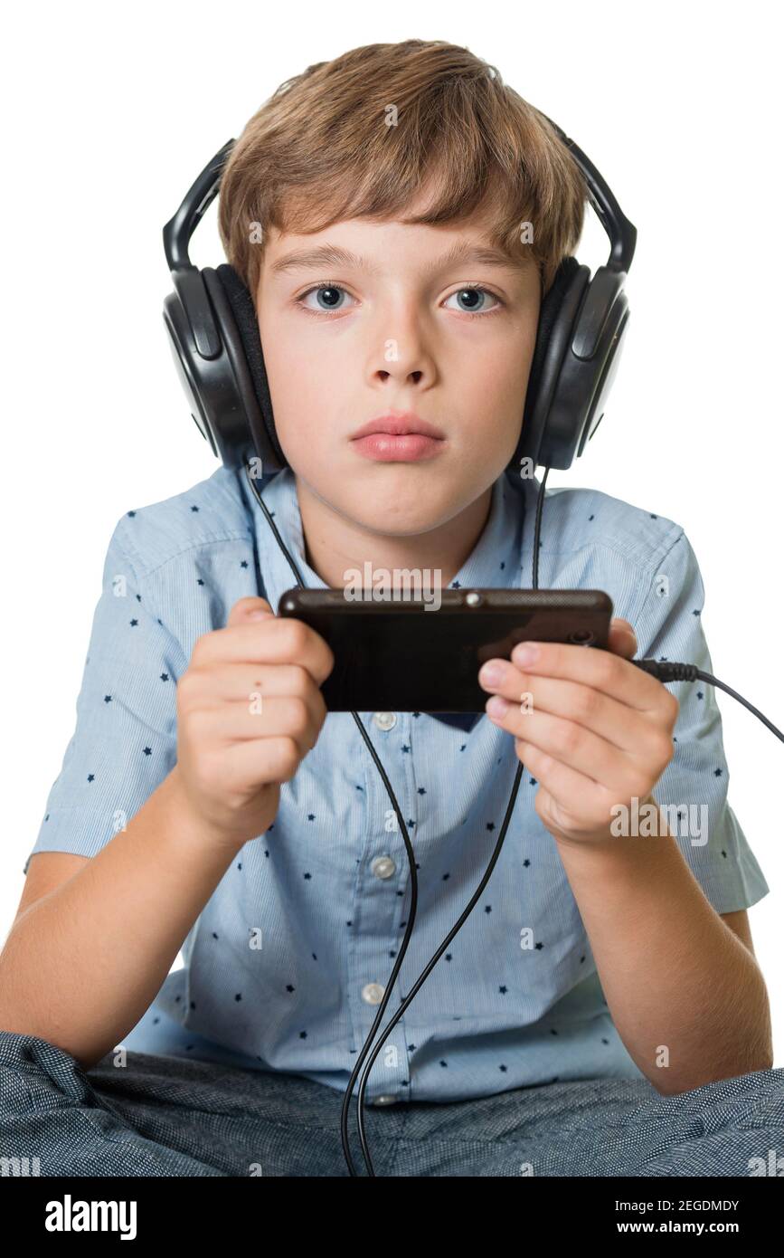 Beau jeune garçon dans un casque d'écoute de la musique avec magnétophone  isolé sur fond vert Photo Stock - Alamy