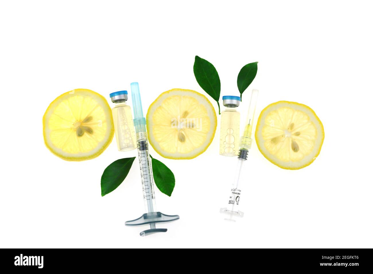 Vitamine C.Santé et beauté .les amulettes de verre, les seringues et les tranches de citron isolées sur fond blanc. Prévention de l'immunité contre les virus.sérum avec Banque D'Images