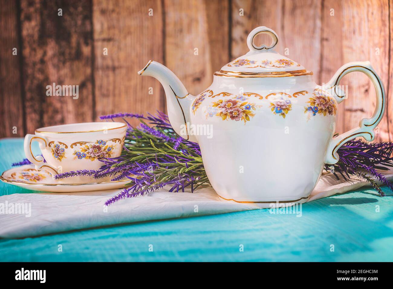 Vue sur une tasse de thé et une belle porcelaine théière sur une table au coucher du soleil Banque D'Images
