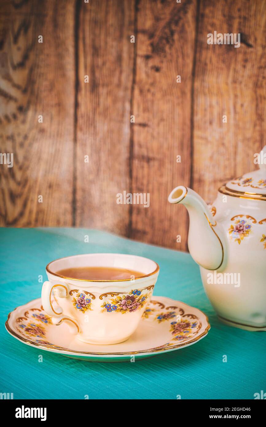 Vue sur une tasse de thé et une belle porcelaine théière sur une table au coucher du soleil Banque D'Images