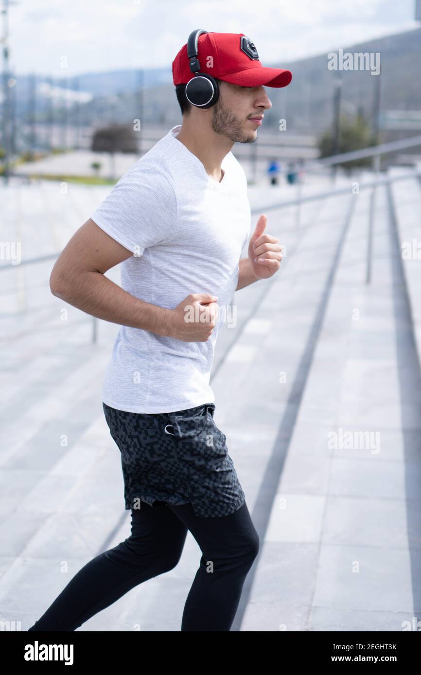 Jeune homme faisant différents exercices d'échauffement et de cardio dans le parc. Banque D'Images