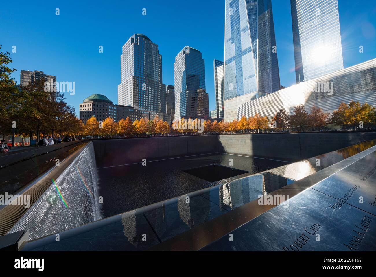 Le soleil illumine les rangées d'arbres d'automne entourant la piscine Memorial South dans le mémorial national du 11 septembre à Lower Manhattan. Banque D'Images