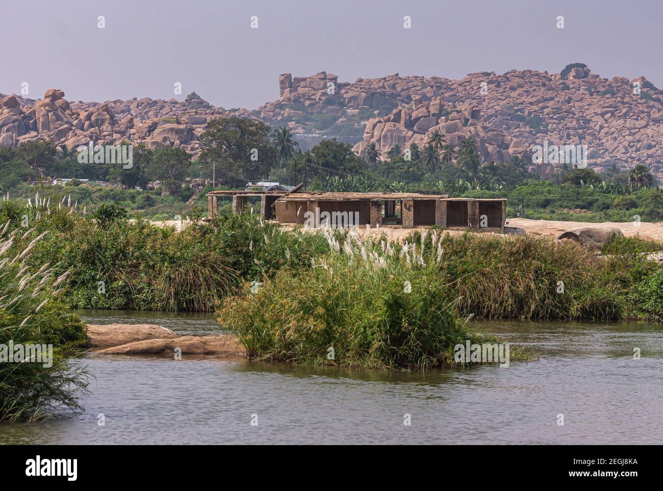 Anegundi, Karnataka, Inde - 9 novembre 2013 : rivière Tungabhadra grise. Les ruines du bâtiment jouxtent le complexe du temple de Sooryanarayana sur son île verte un Banque D'Images