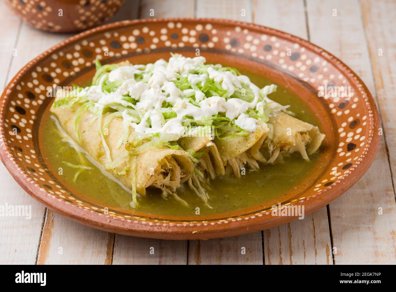 Enchiladas de poulet vert mexicain servi sur une assiette en argile traditionnelle Banque D'Images