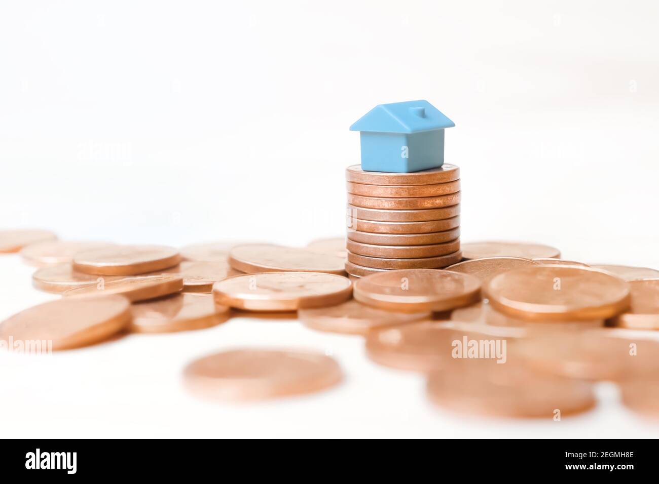Les pièces de monnaie de la maison de jouets bleue s'empilent sur fond