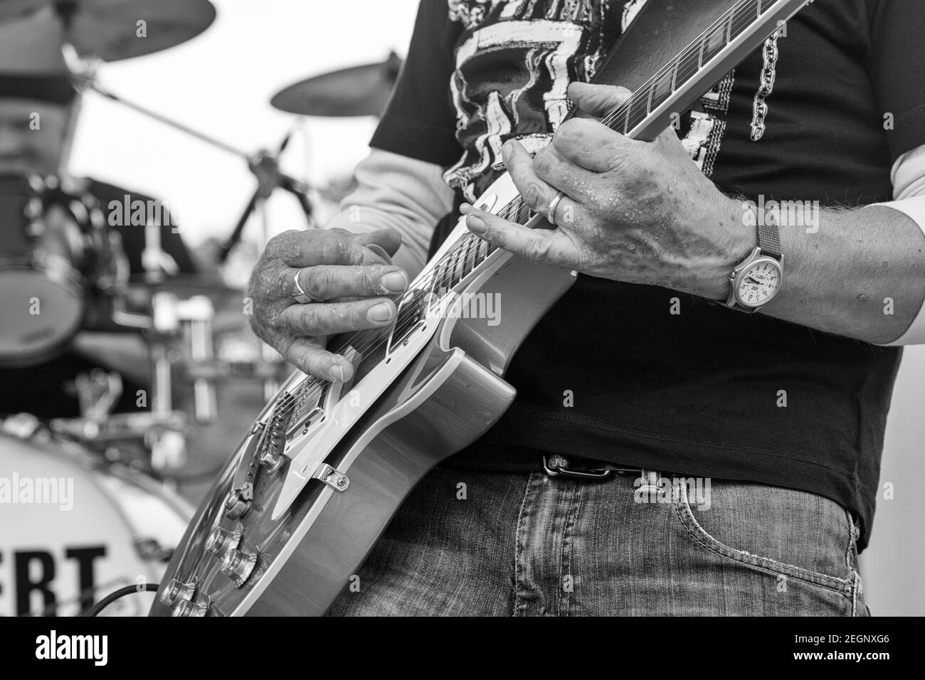 Gros plan noir et blanc de la guitare jouant avec le tambour défini en arrière-plan Banque D'Images