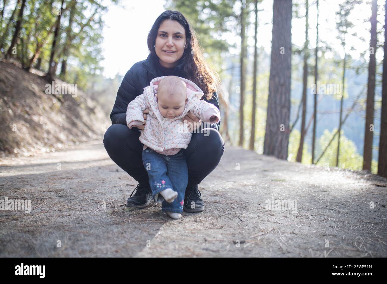 Bonne femme tenant son adorable bébé dans la forêt Banque D'Images