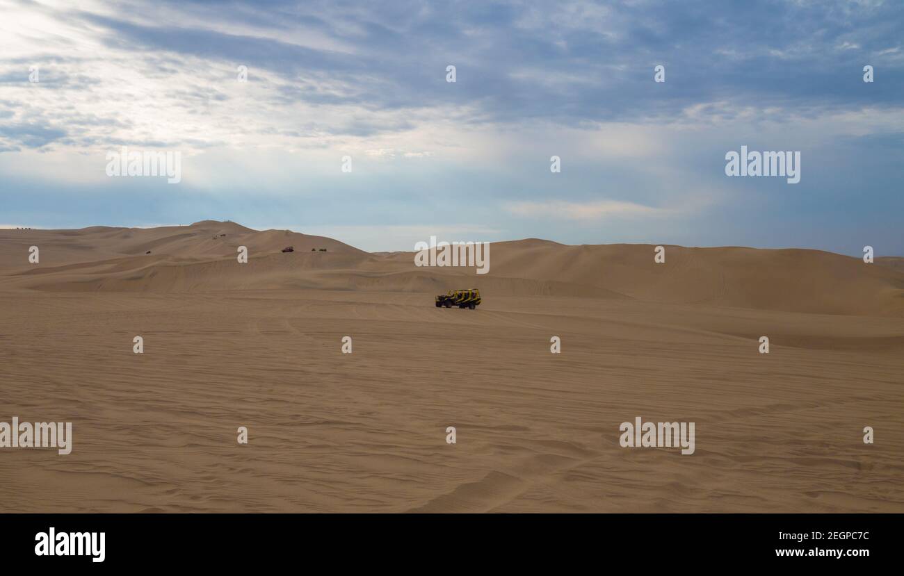 Buggy jaune au désert de l'ICA au pérou, dunes de sable sous le ciel bleu Banque D'Images