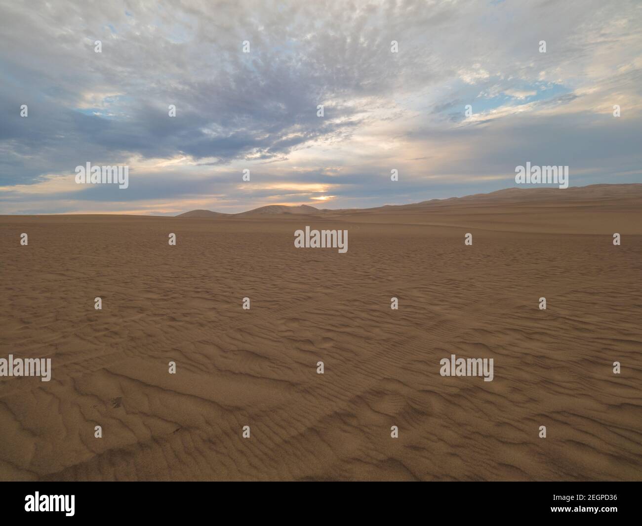 Coucher de soleil dans le désert, la lumière brille sur le sable doré sous le ciel bleu doré Banque D'Images