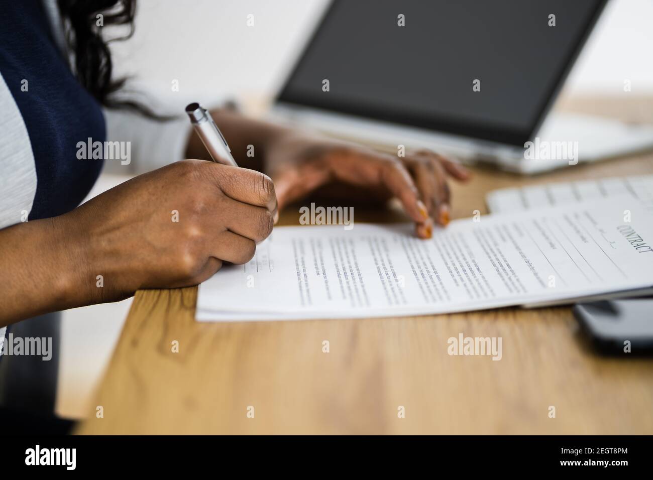 Un avocat africain signant un document ou un accord commercial juridique Banque D'Images