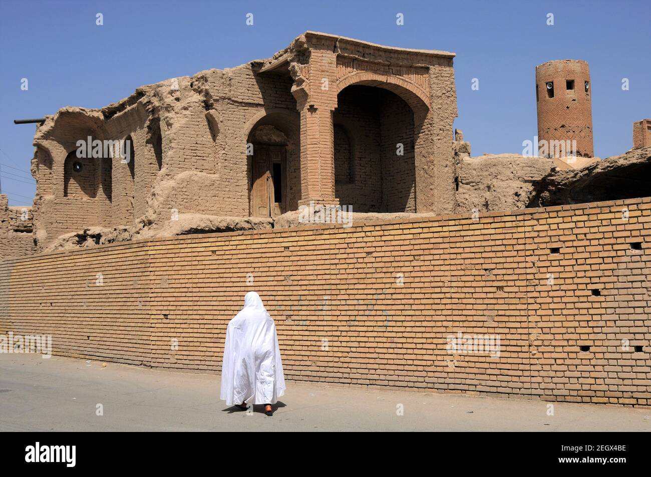 Maisons traditionnelles iraniennes. Une iranienne portant une robe blanche. Une ville médiévale en Iran. Barzaneh, Khorasan du Nord, Iran. Banque D'Images