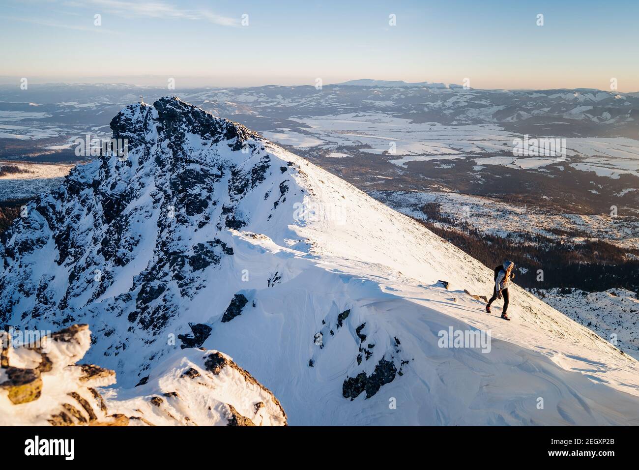 Randonnée pédestre dans la chaîne de montagne arrière-plan bannière - escalade femme alpiniste porter une veste de capuche en hiver pendant le coucher de soleil violet Banque D'Images