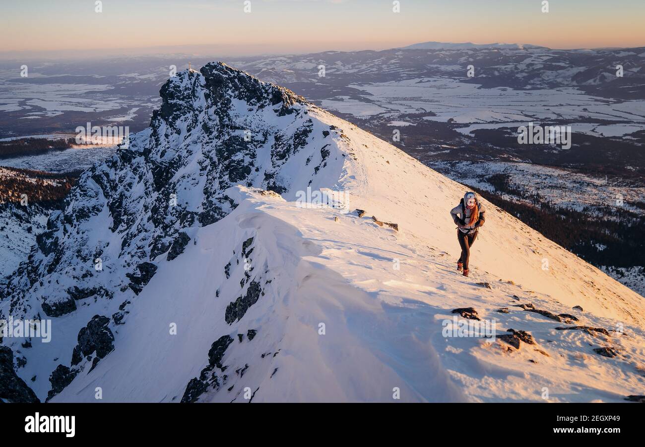 Randonnée pédestre dans la chaîne de montagne arrière-plan bannière - escalade femme alpiniste porter une veste de capuche en hiver pendant le coucher de soleil violet Banque D'Images