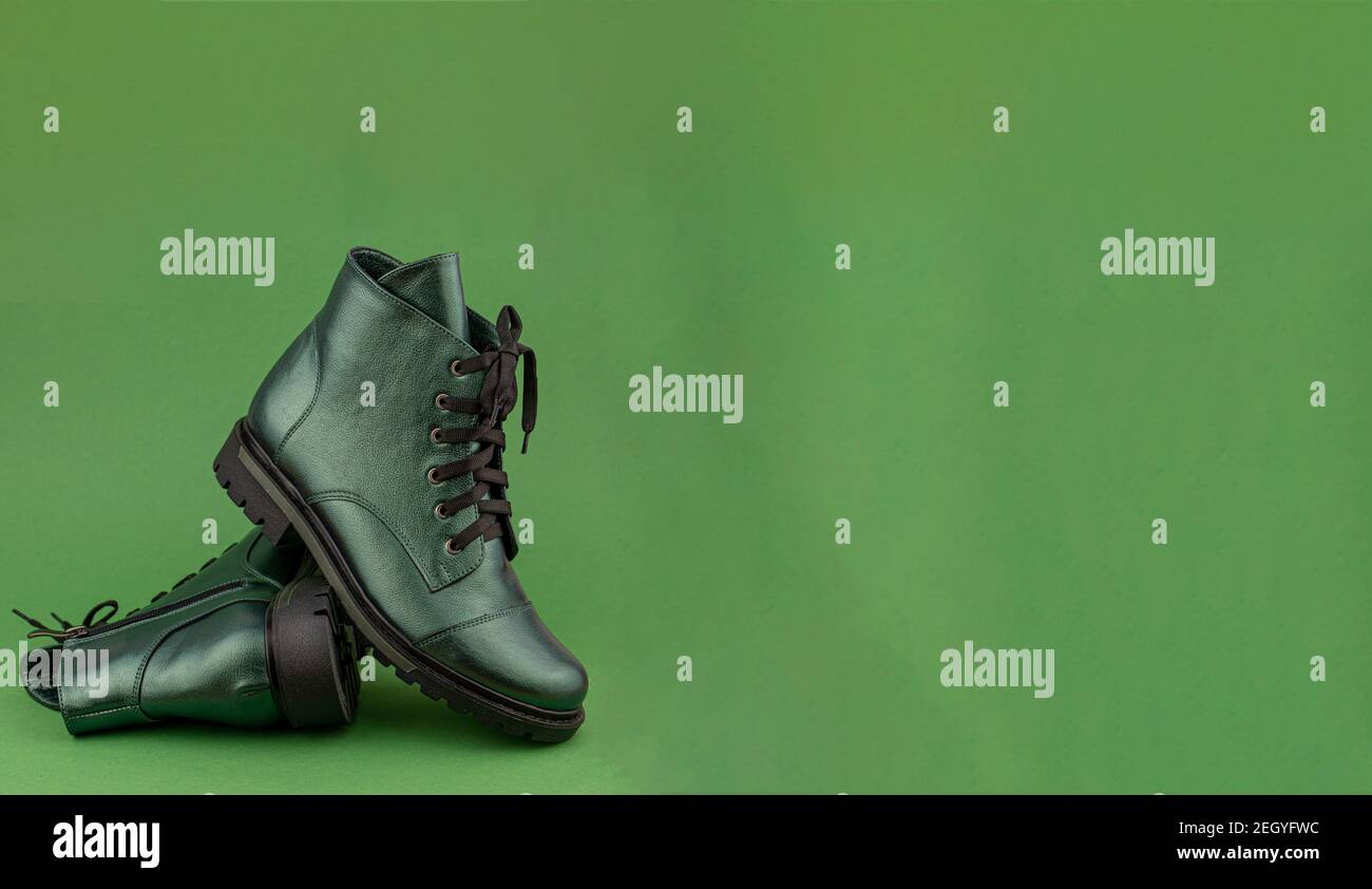 Bannière en cuir vert pour chaussures. Bottes d'hiver et de printemps hors saison. Chaussure élégante isolée en arrière-plan. Gros plan. Lacets, semelle de tracteur. Style décontracté. Copier Banque D'Images
