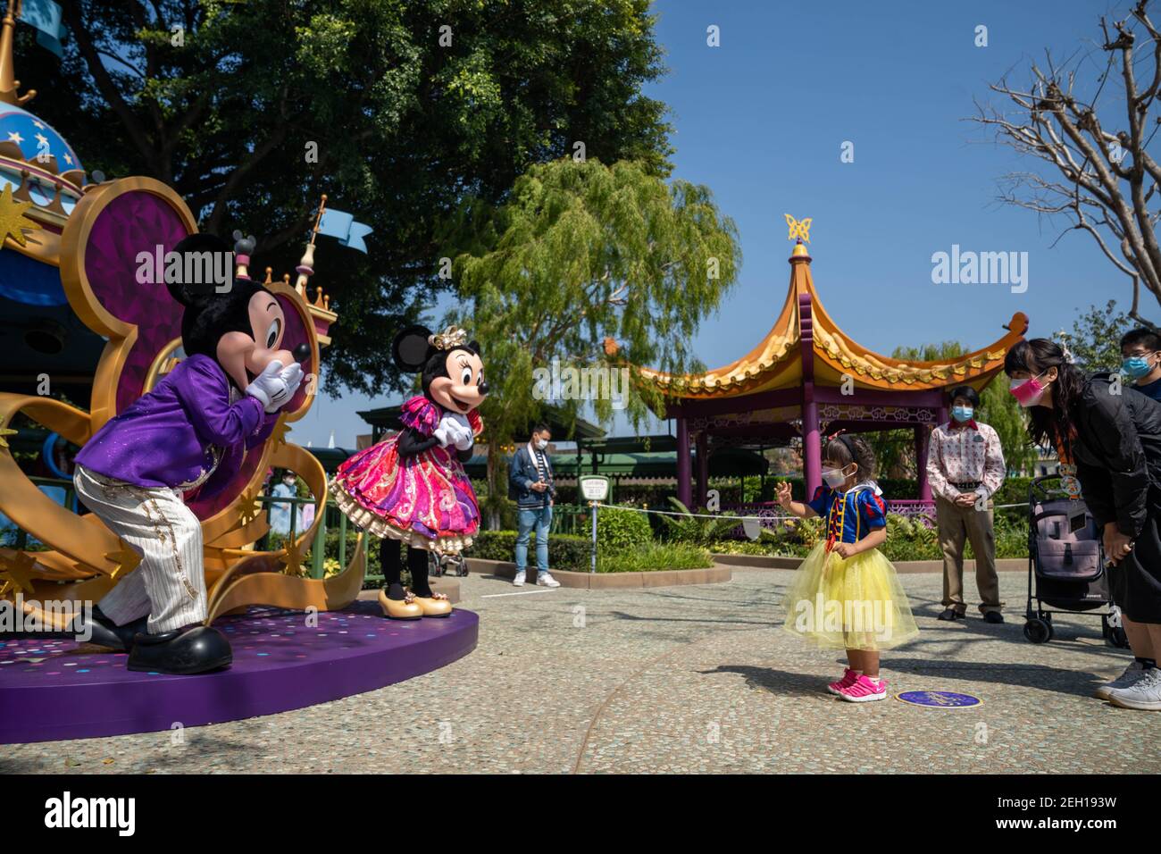 Un enfant interagit avec les acteurs habillés comme les personnages de dessin animé Disney Mickey Mouse et Minnie Mouse tout en maintenant la distance sociale entre eux pendant la réouverture du Hong Kong Disneyland Resort.le Hong Kong Disneyland Resort rouvre sa porte aux visières alors que le gouvernement de la ville a assoupli les restrictions de verrouillage Le taux d'infection du coronavirus Covid-19 a diminué de façon significative ces derniers jours. Banque D'Images