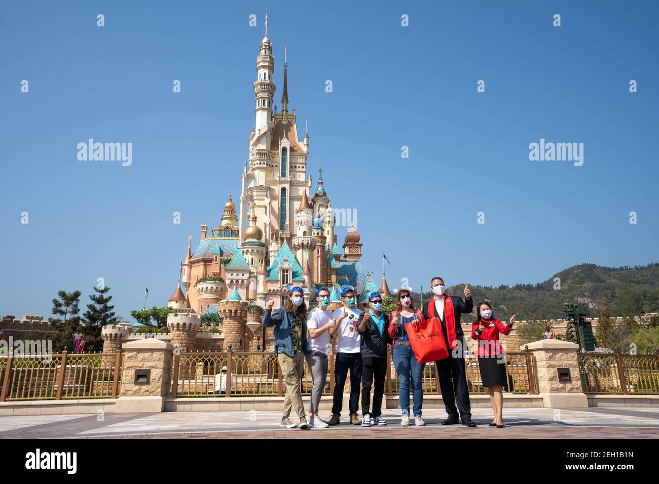 Michael Moriarty (R2), Le directeur général de Hong Kong Disneyland Resort pose pour la photo avec les visiteurs devant le château des rêves magiques lors de la réouverture de la station.le Hong Kong Disneyland Resort rouvre sa porte aux visières alors que le gouvernement de la ville a assoupli les restrictions de verrouillage comme le taux d'infection de la Le coronavirus Covid-19 a considérablement diminué ces derniers jours. (Photo de Geovien SO / SOPA Images / Sipa USA) Banque D'Images