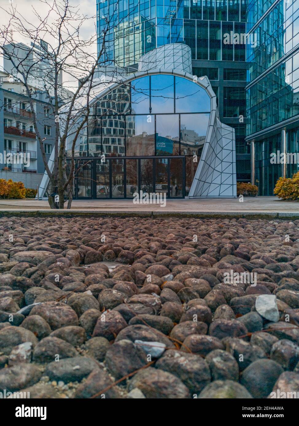 Varsovie novembre 9 2019 petit bâtiment blanc moderne avec vitreux façade réfléchissante sur beaucoup de petites pierres Banque D'Images