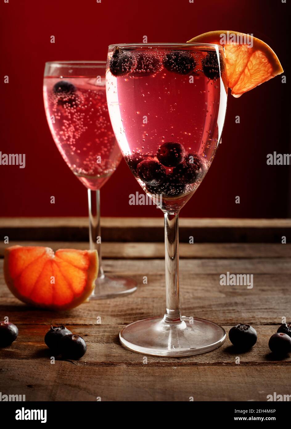 deux verres avec cocktail rouge sur une table rustique en bois Banque D'Images