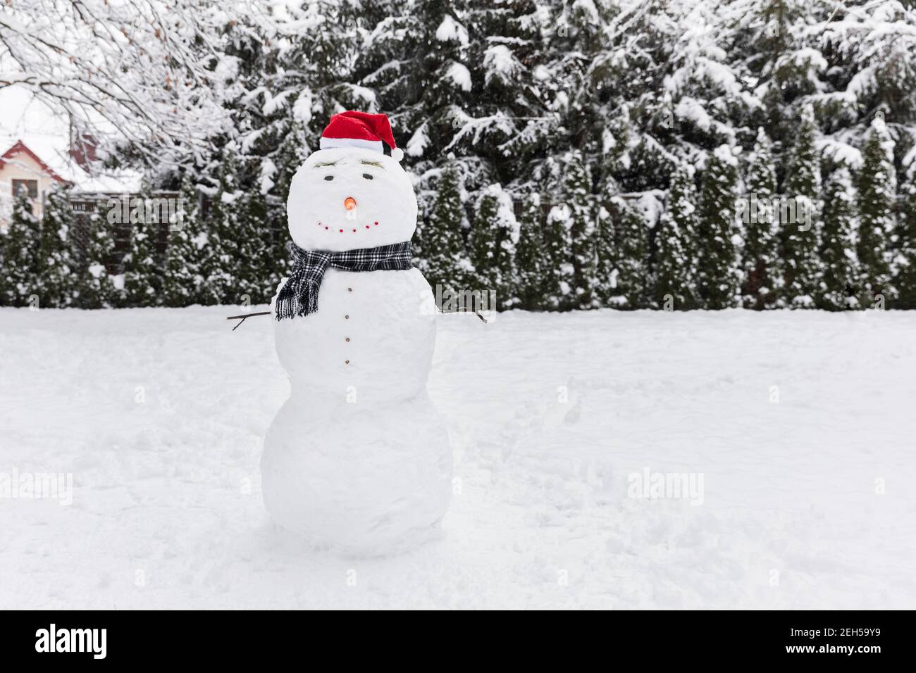 Bonhomme de neige plein d'entrain. Bonhomme de neige portant un chapeau de Père Noël. Banque D'Images