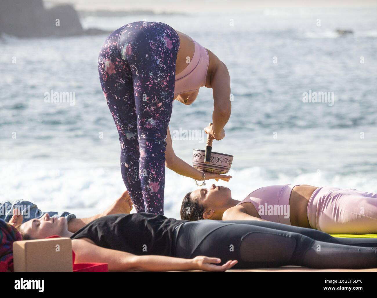 Las Palmas, Grande Canarie, Îles Canaries, Espagne. 19 février 2021. Avec des salles de gymnastique et des écoles de yoga fermées en raison des restrictions Covid, le climat sur Gran Canaria facilite le déplacement des cours de yoga à la plage de la ville. Crédit : Alan Dawson/Alay Live News. Banque D'Images