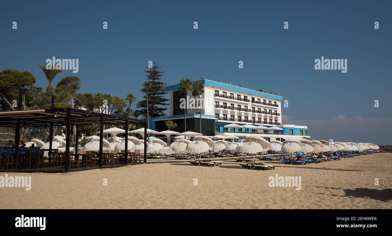 Palm Beach avec des parasols de plage et des touristes et des hôtels abandonnés à la ville fantôme, Famagousta, Chypre du Nord Banque D'Images