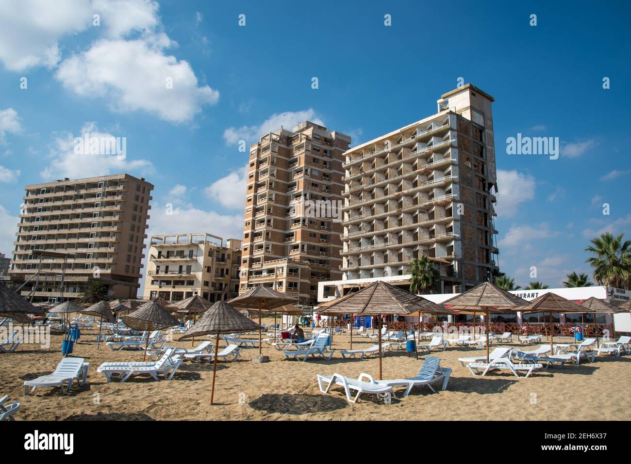 Palm Beach avec des parasols de plage et des touristes et des hôtels abandonnés à la ville fantôme, Famagousta, Chypre du Nord Banque D'Images