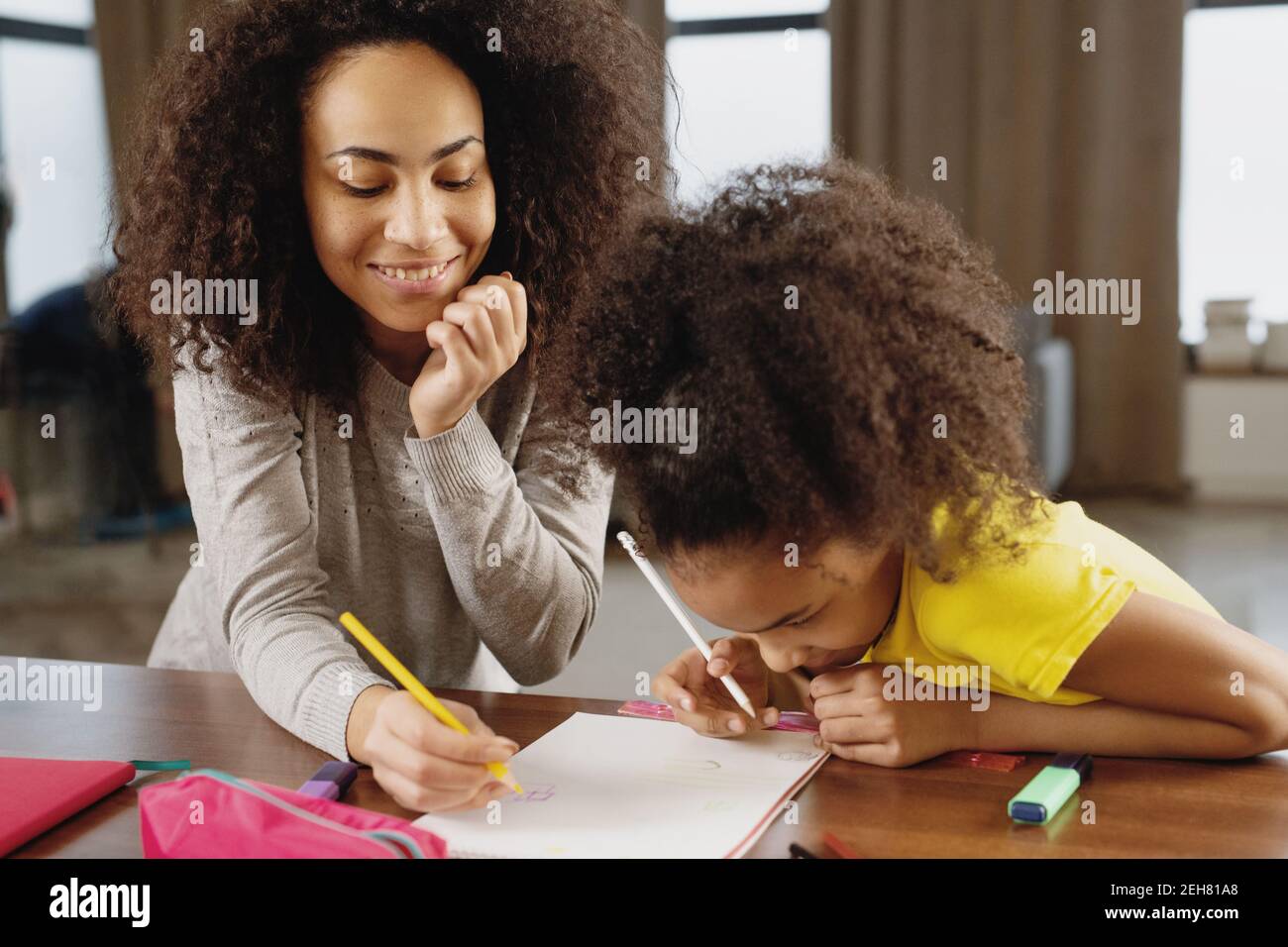 Mère et fille faisant leurs devoirs ensemble à la maison. Banque D'Images