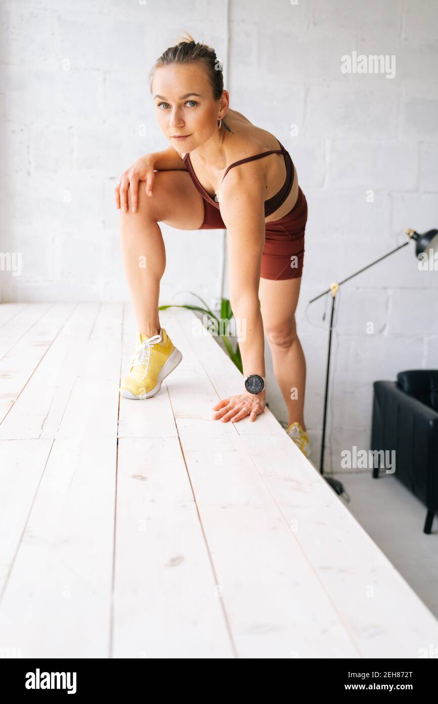Une femme de forme physique attrayante avec un corps sportif parfait dans  la pose de vêtements de sport se tenir au seuil de la vitre Photo Stock -  Alamy