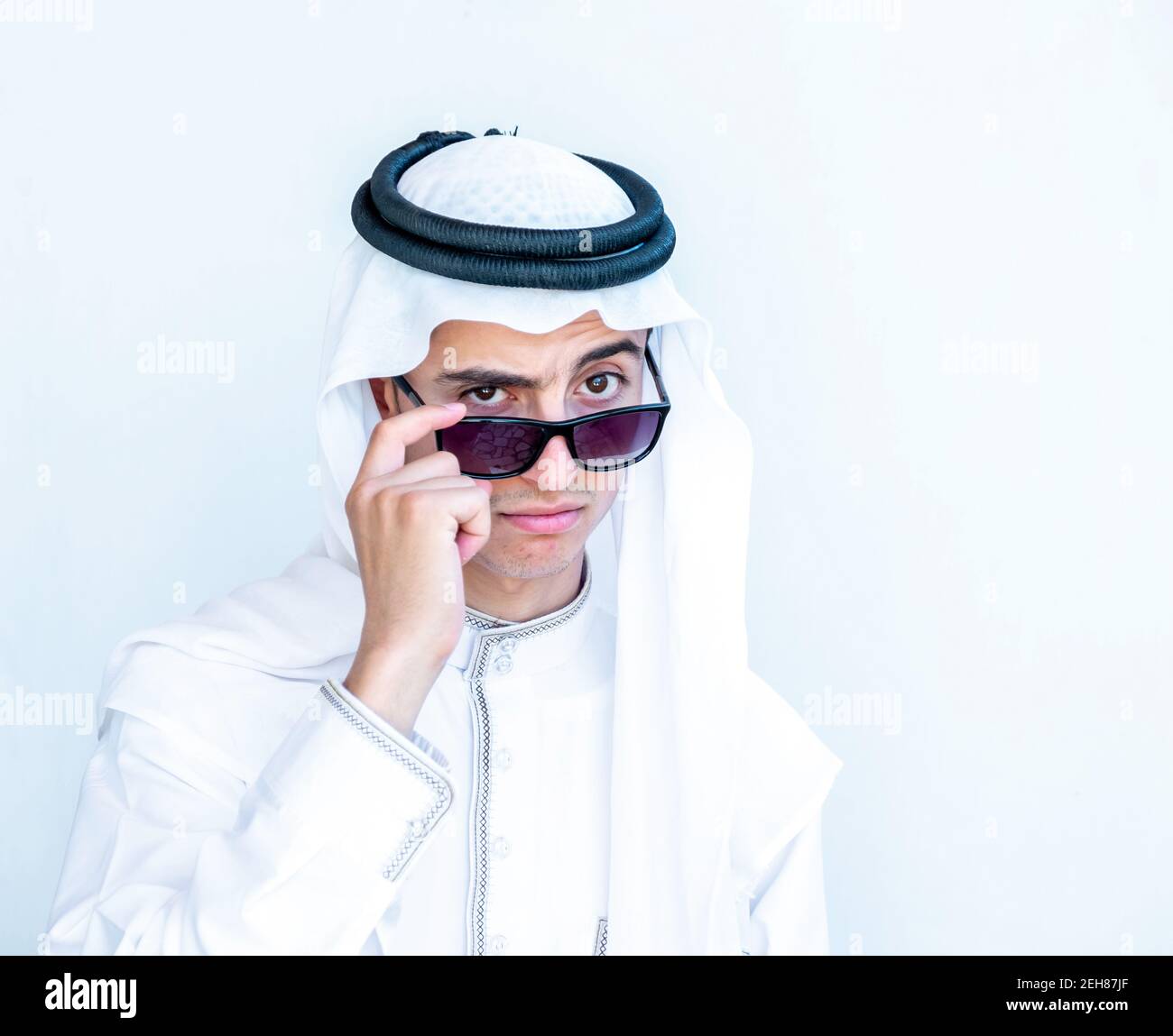 Jeune homme arabe portant des lunettes de soleil et des lunettes de peeking Banque D'Images