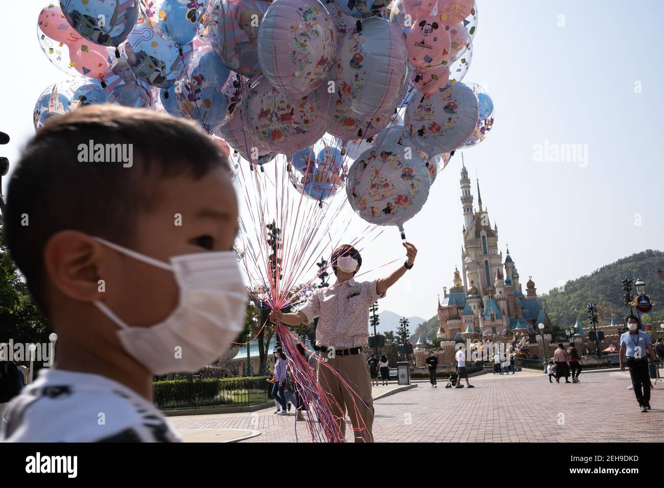 Un employé tenant des ballons gonflables pendant la réouverture du parc Disneyland de Hong Kong alors que le gouvernement perd les mesures de distance sociale du coronavirus (Covid-19). Banque D'Images