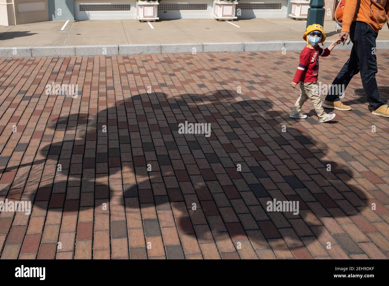 Un enfant marche à travers des ombres de ballons lors de la réouverture du parc Disneyland de Hong Kong alors que le gouvernement perd les mesures de distance sociale du coronavirus (Covid-19). Banque D'Images