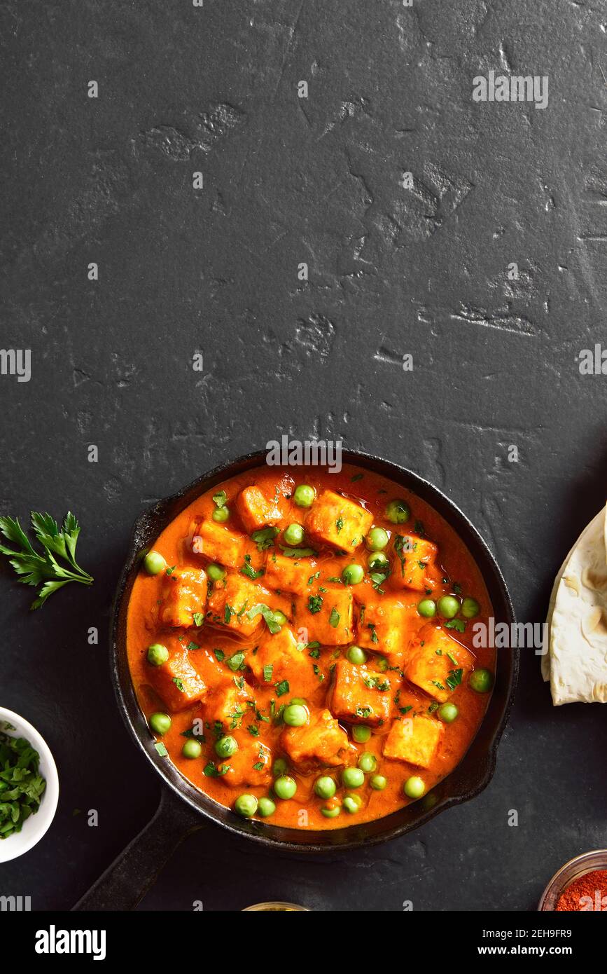 Masala beurre paneer. Cari de fromage cottage de style indien dans une casserole sur fond de pierre noire avec espace de texte libre. Vue de dessus, plan d'appartement Banque D'Images