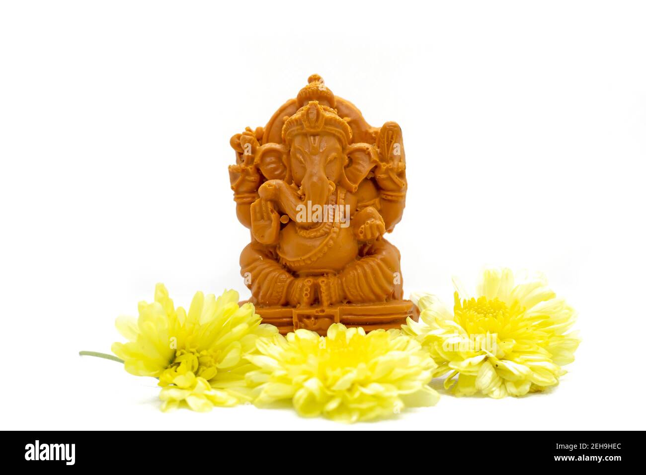 Ganesha statue de dieu hindou avec des fleurs sur fond blanc. Banque D'Images