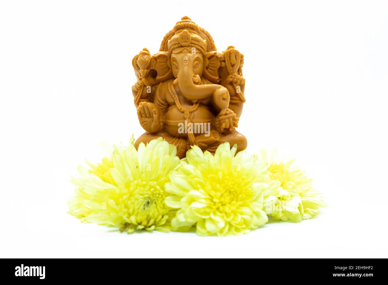 Ganesha statue de dieu hindou avec des fleurs sur fond blanc. Banque D'Images