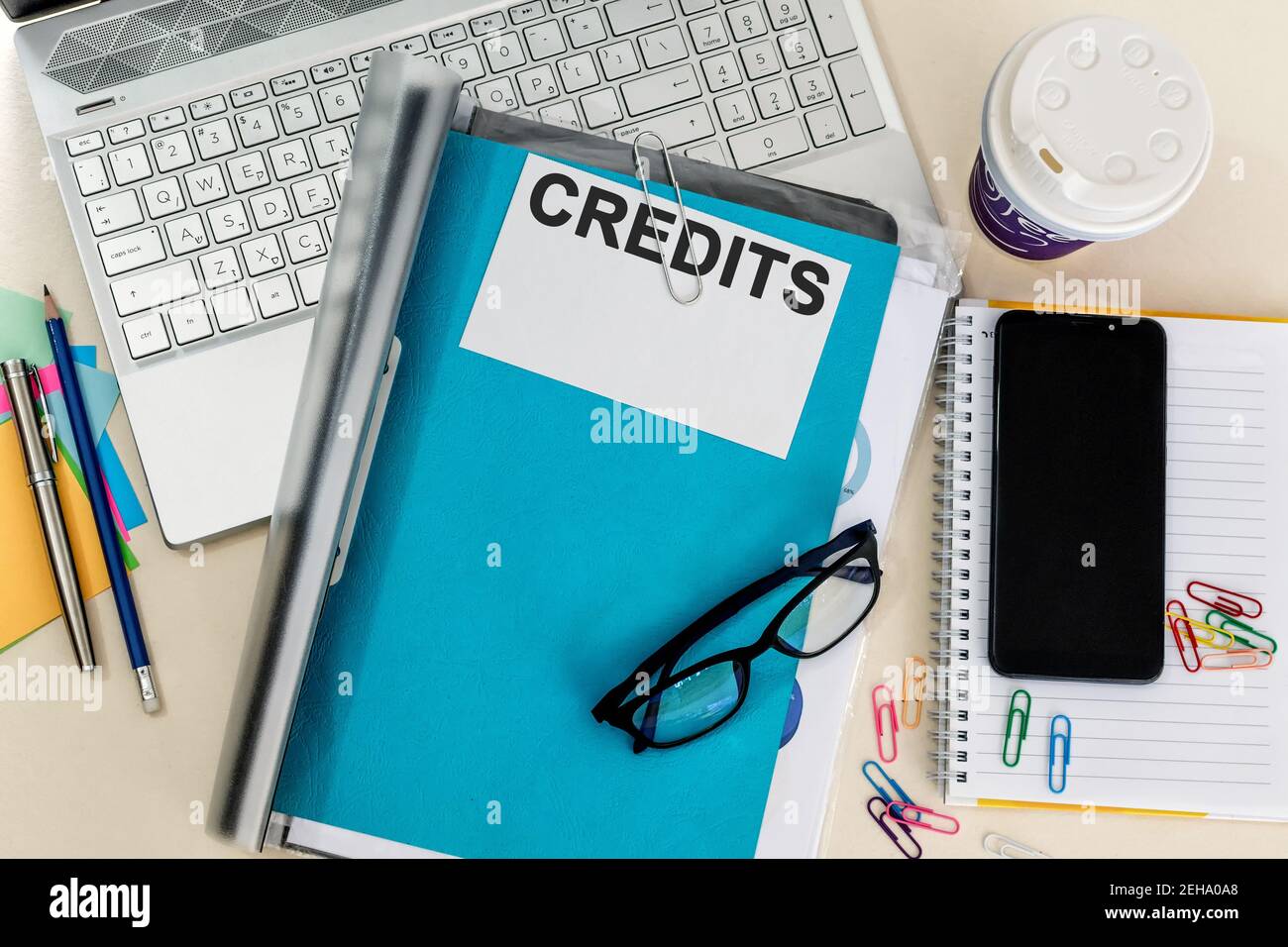 Vue de dessus des lunettes sur un dossier bleu intitulé « CREDITS » sur un ordinateur portable au bureau Banque D'Images