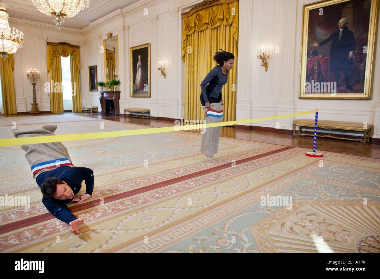 La première dame Michelle Obama participe à une course de sacs de pommes de terre avec Jimmy Fallon dans la salle est de la Maison Blanche lors d'une « nuit tardive avec Jimmy Fallon » marquant le deuxième anniversaire de la « allons bouger ! » Initiative, 25 janvier 2012. Banque D'Images