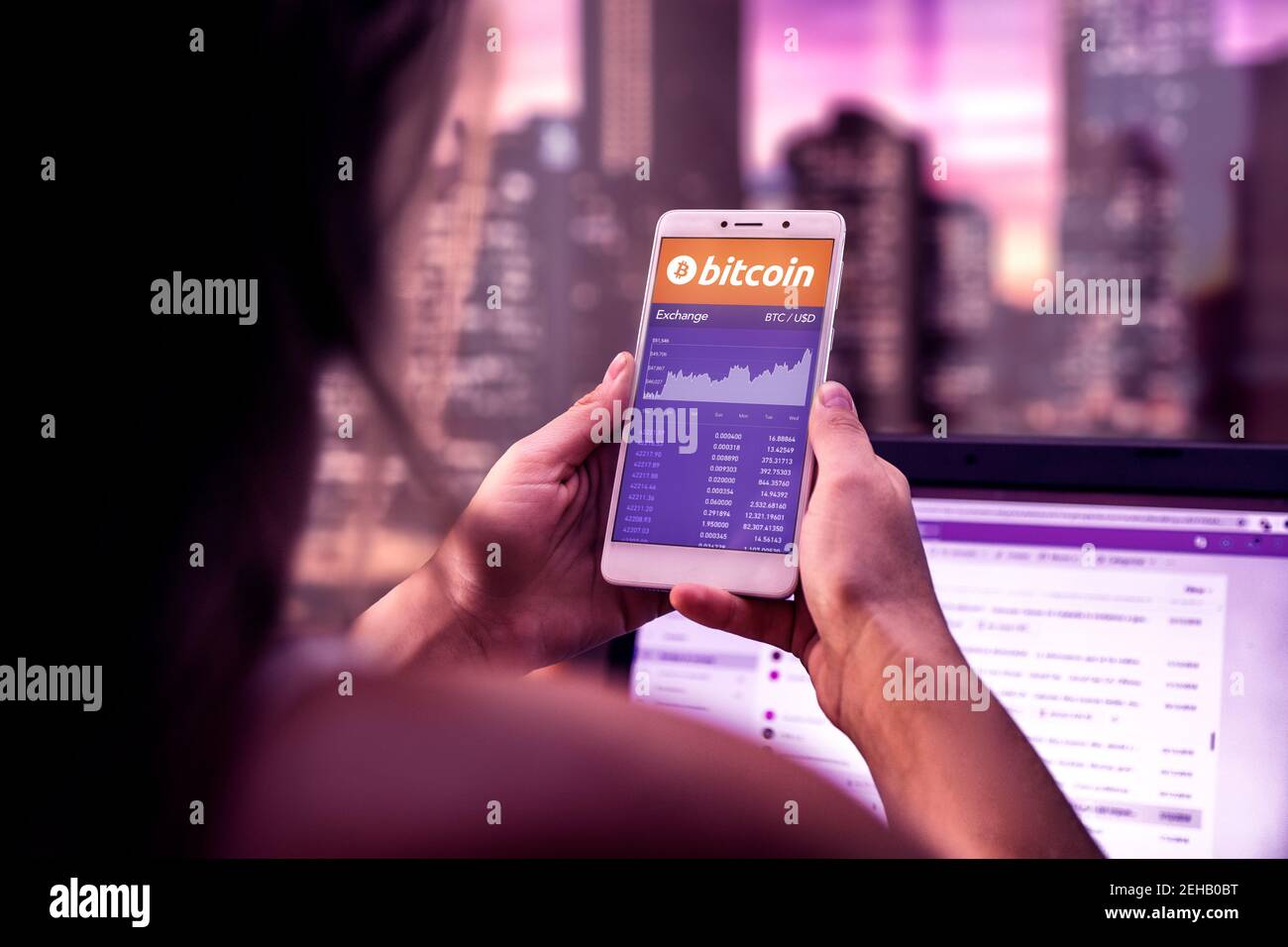 ROSARIO, ARGENTINE - 19 FÉVRIER 2021: Tableau Bitcoin sur un écran de téléphone mobile. Femme d'affaires avec un smartphone entre ses mains. Investissement d'argent virtuel Banque D'Images