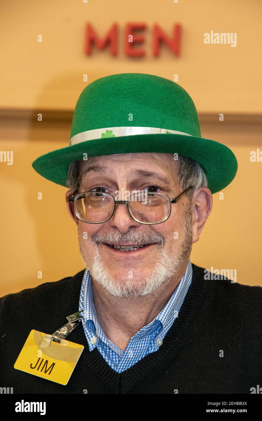 3-5-2019 Tulsa USA - homme âgé avec un sourire mignon et la barbe et les lunettes sont en service aux caisses dans le rayon de port de l'épicerie Nom tag-Jim-et leprechaun chapeau Banque D'Images