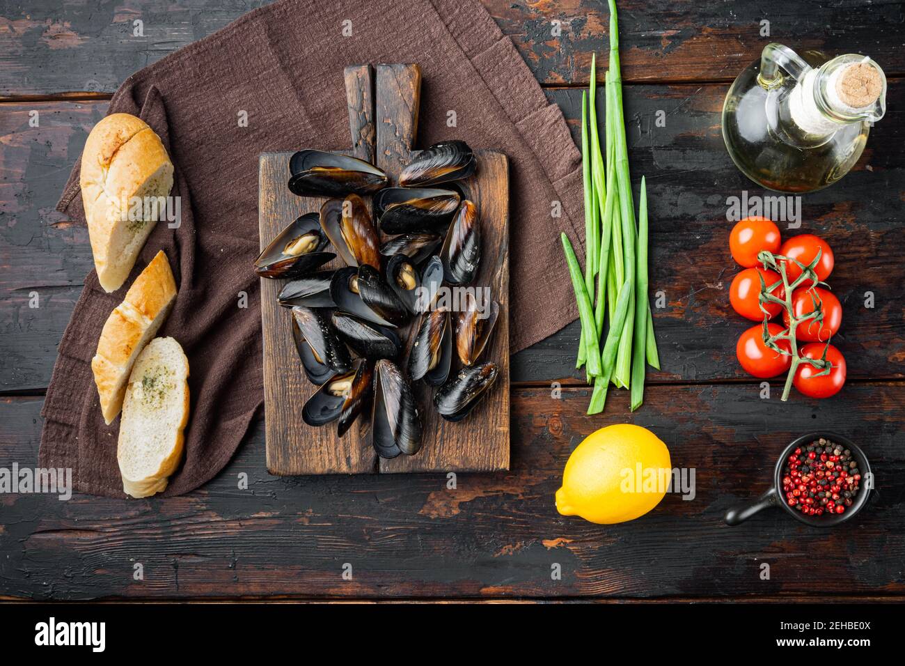 Moules ragoût dans le vin blanc et les herbes, sur la planche à découper en bois, sur le fond de la table en bois sombre, sur le dessus de l'appartement avec vue Banque D'Images