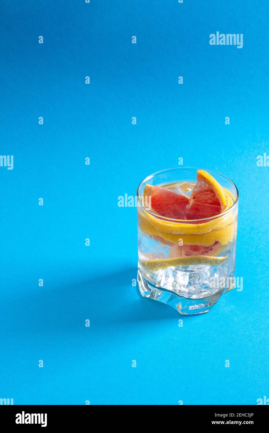 Un verre d'eau avec un cube de glace et une tranche de pamplemousse frais. Concept de détox Banque D'Images
