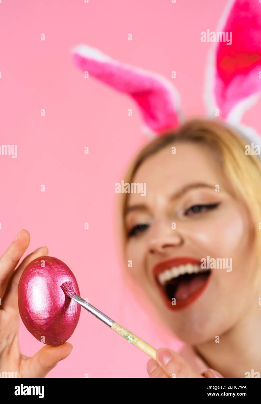 Le jour de Pâques. Femme en oreilles de lapin peignant des œufs de Pâques. Idées de décoration d'oeufs. Banque D'Images