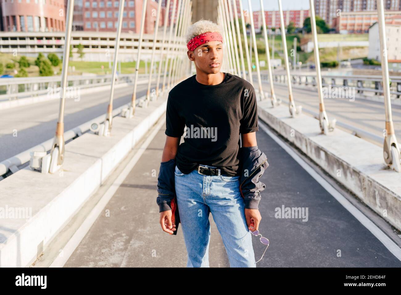 Beau garçon noir avec foulard debout au milieu de le pont qui s'éloigne Banque D'Images