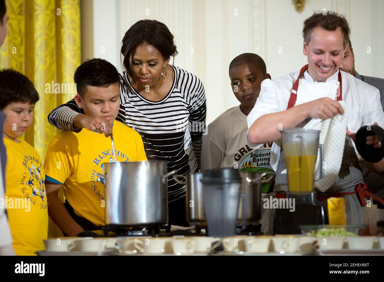 La Première Dame Michelle Obama et le chef Thomas Ciszak inscrivez-vous l'école les enfants dans la préparation du repas annuel de récolte d'automne dans l'East Room de la Maison Blanche, le 14 octobre 2014. Banque D'Images